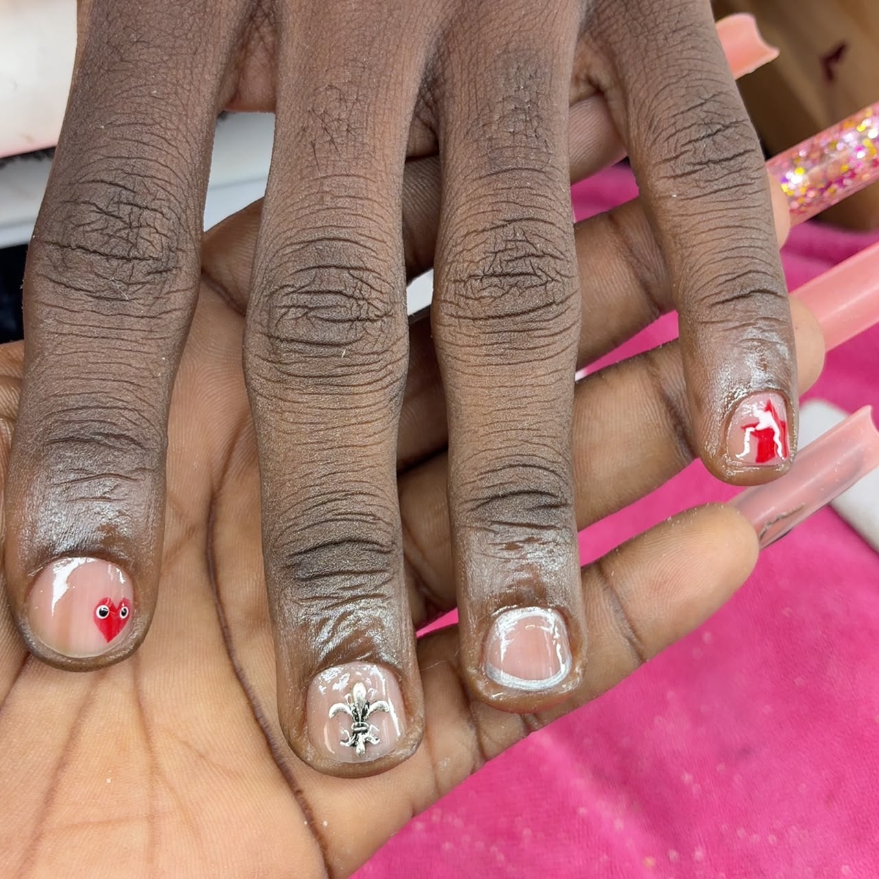 Men's manicure with nail art — clean short nails with fleur-de-lis charm and heart detail