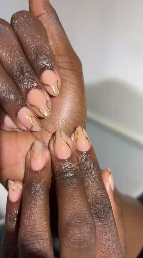 Almond nude nails with abstract gold line art