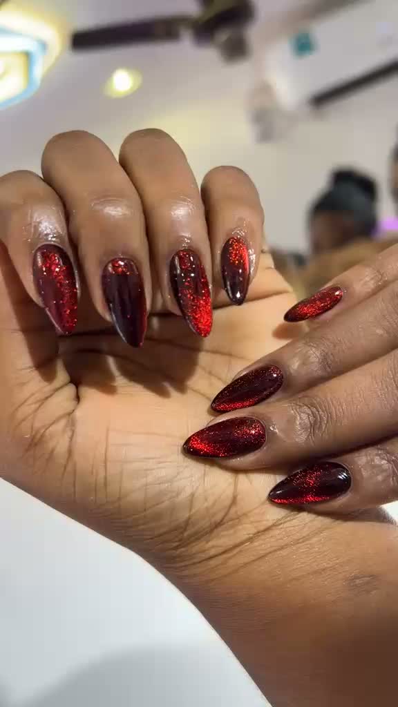 Dark red and black almond nails with cat-eye effect